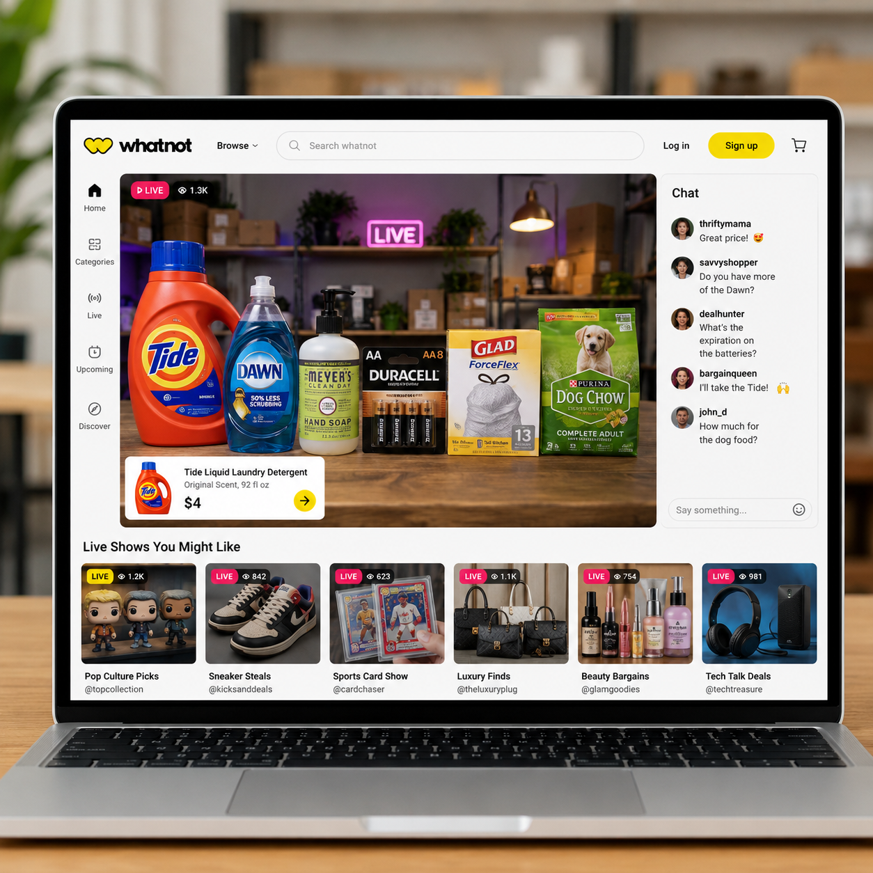 Whatnot live shopping website displayed on a laptop featuring laundry detergent, batteries, hand soap, pet supplies, and other everyday household products available through live auctions and Buy It Now sales.